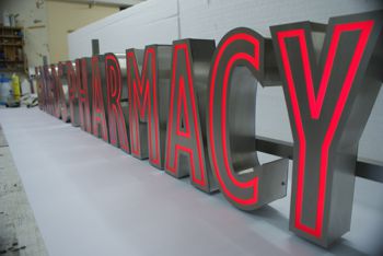 Internally illuminated brushed stainless steel built up letters with red acrylic mimicking neon style.