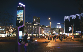 A streetview in a city at night with a smart kiosk