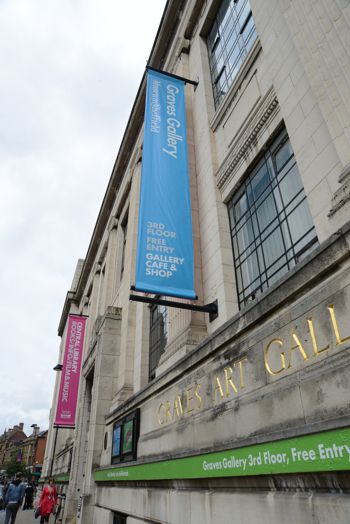 Promotional banner hanging from the side of an art gallery 