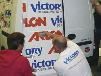 Van being wrapped in Victory Design's Logo.