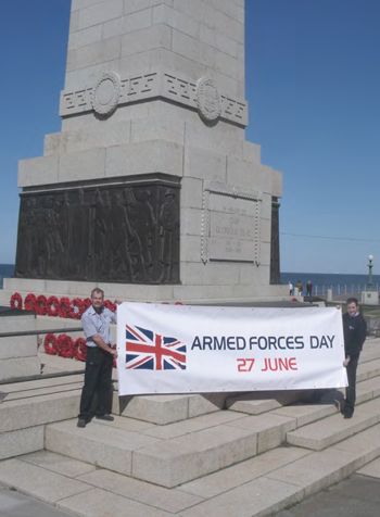 Banner being held in front of a war memorial