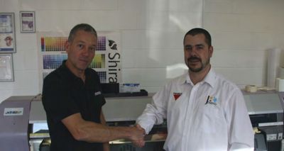 Richard Towers, Production Manager and co-owner of Fast Signs in Peterborough and Loic Delor, Managing Director of Josero in front of a printer on site at Fast Signs.