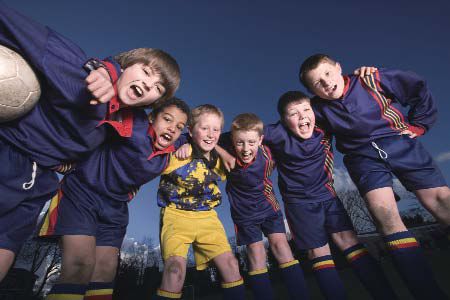 Childrens football team in a huddle.