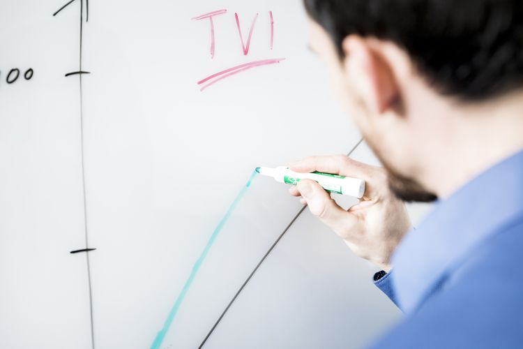 Man drawing a graph on a whiteboard.