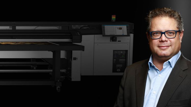 Terry Raghunath from HP, with a wide format printer in the background.