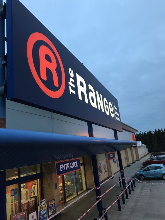 A large flex face sign using NovaTex profiles, installed above a shop and illuminated with LEDs. 