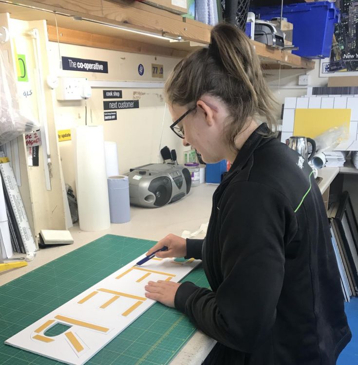 Student at Walsall College cutting out letters as part of her apprenticeship