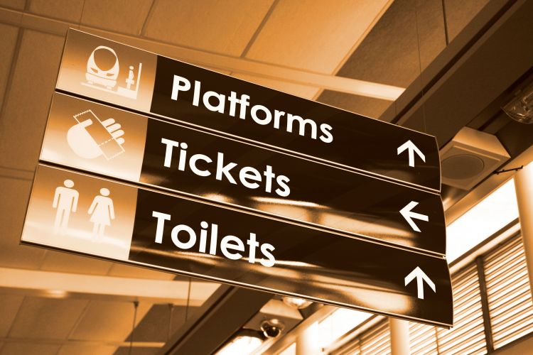 Directional signage showing directions in a train station, using a signage system from Vista Systems.