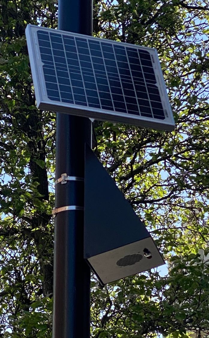 A solar panel and loudspeaker on a lamppost