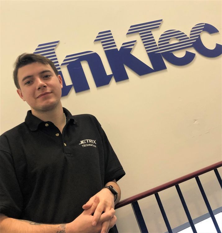 Dann Hutt infront of a sign saying InkTec