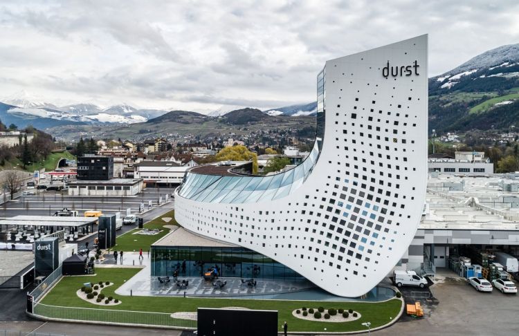 The headquarters of Durst in Italy with beautiful mountains in the background.