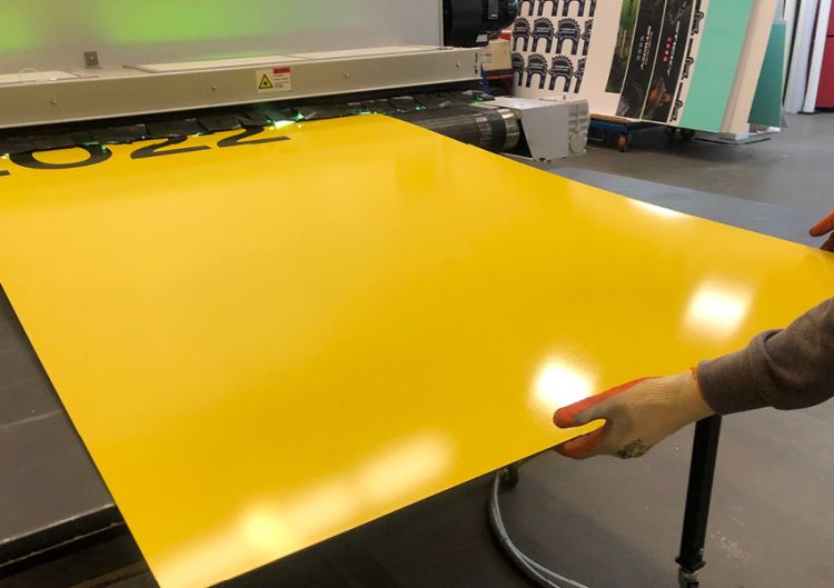 The Bürkle LFC 2100 UV liquid laminator in use creating hoardings