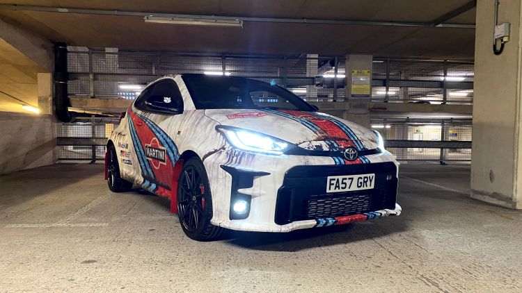 A 'barn find' vehicle wrap on a car to make it look like a WRC rally car that's been sitting in a barn for many years.
