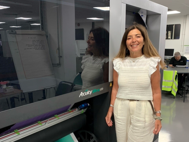 Tracy Dineen standing by Fujifilm Acuity Printer