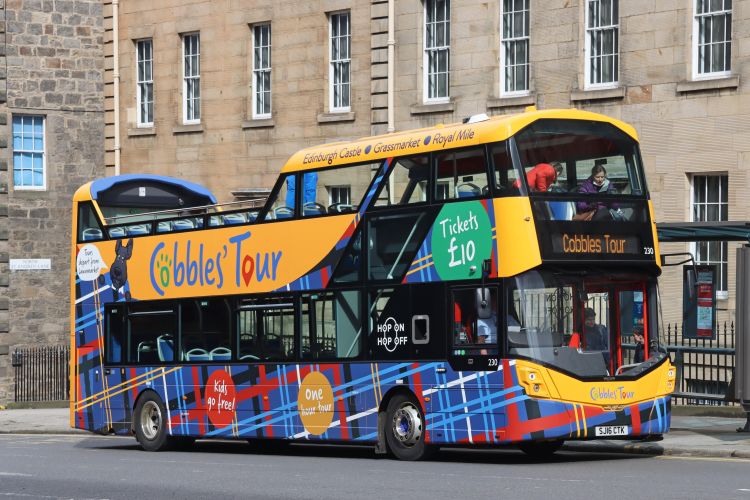 Open top bus covered by large format printed graphics