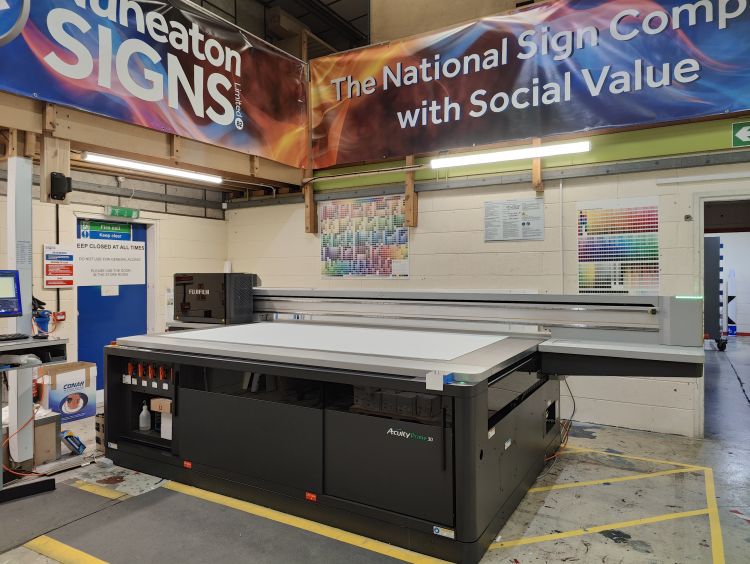 An acuity prime 30 flatbed printer is positioned in the middle of a signage workshop