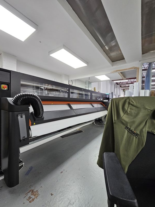 A long print room with the HP Stitch printer going across the length of it