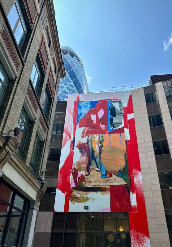 A richly coloured mural stands out between buildings of steel and glass
