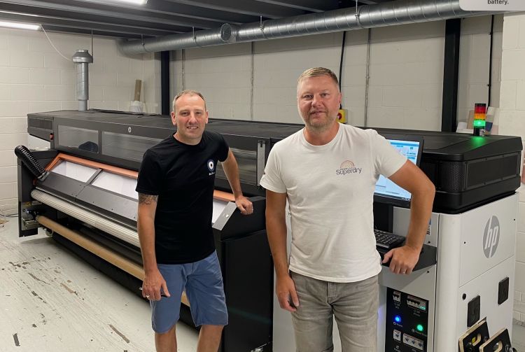 Two directors of Manchester Print services stand next to Manchester Print Services endorses UFabrik Soft Backlit their HP Stitch S1000 dye sublimation printer