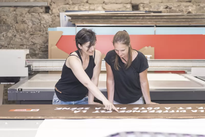 Two women review a print from their swissQprint Oryx printer